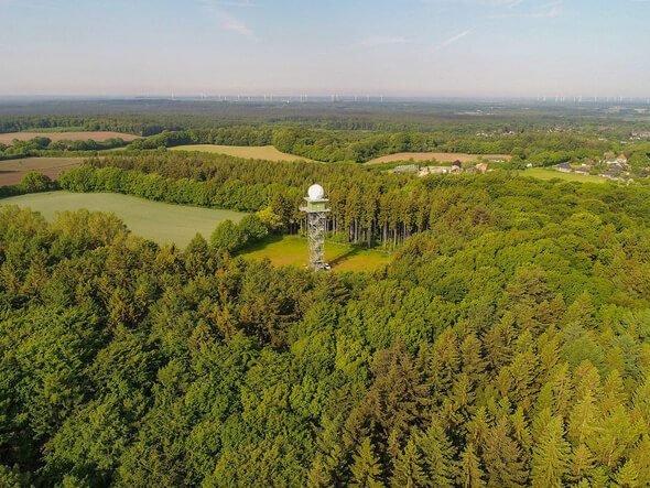 Der Wetterradarturm des Deutschen Wetterdienstes in Boostedt (Schleswig-Holstein). Im Hintergrund in der Schutzzone von 5 bis 15 km Entfernung Windenergieanlagen (Bild: DWD)