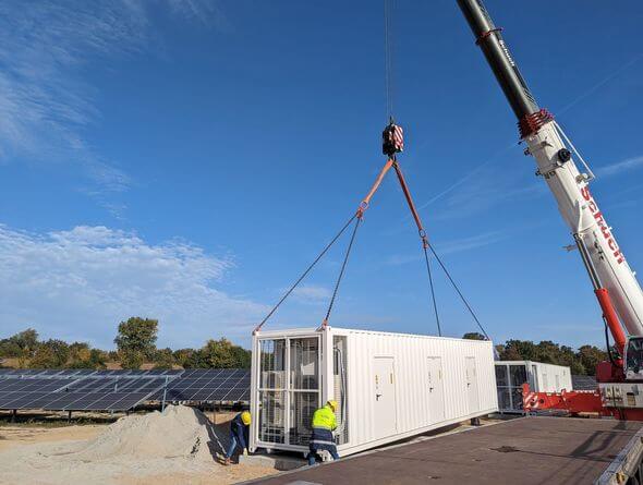 Der Batteriespeicher für den Solarpark Bruchsal wird angeliefert und mit einem Schwerlastkran auf das Fundament gehoben. (Bild: EnBW)