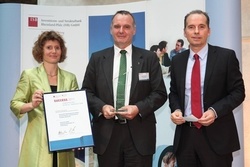 Eveline Lemke (links), Wirtschaftsministerin von Rheinland-Pfalz, übergibt den Innovationspreis an Frank Scheuch (Mitte); Dr. Ulrich Link (rechts) Geschäftsführer der Investitions- und Strukturbank Rheinland-Pfalz (ISB) GmbH